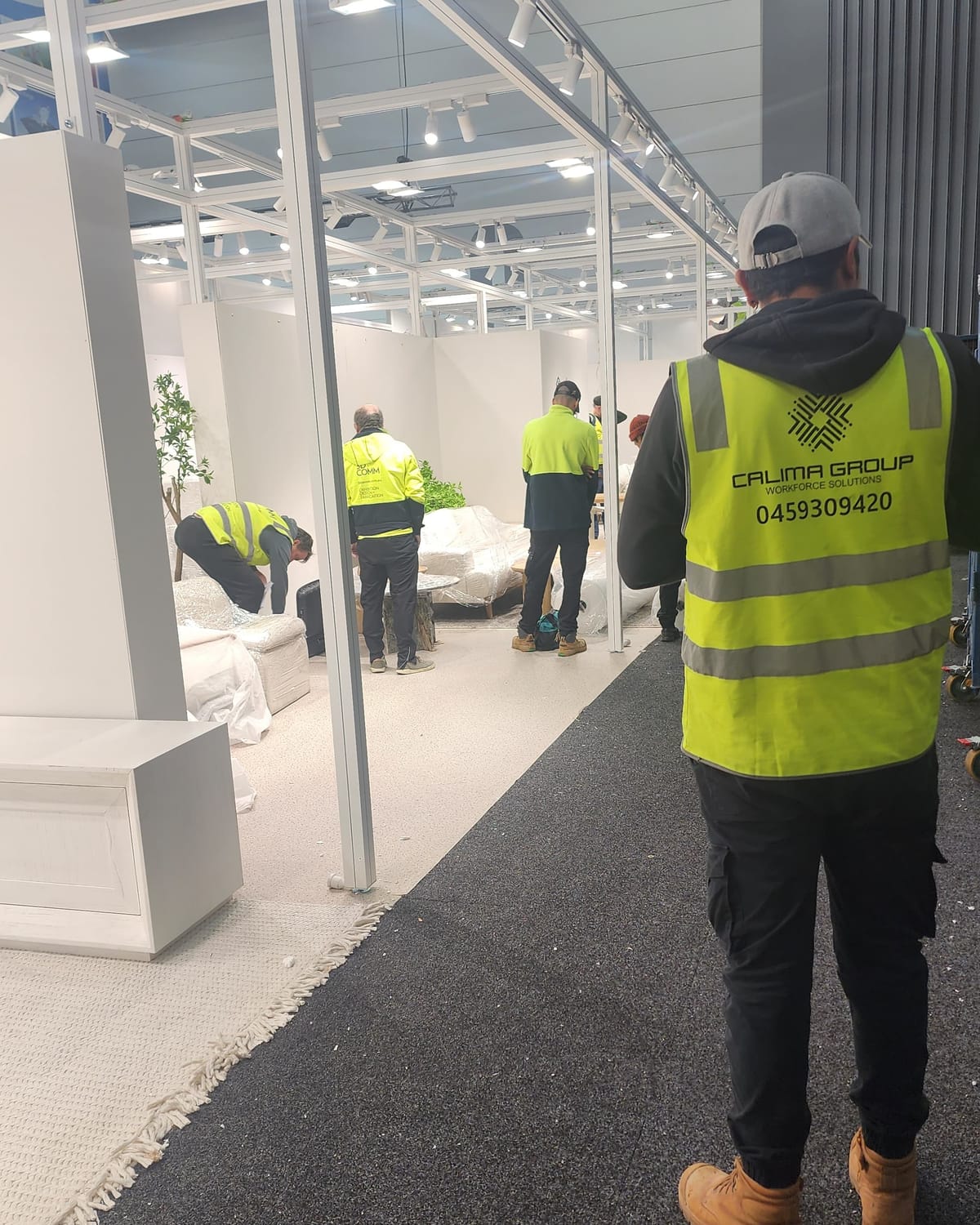 Calima crew in branded hi-vis building an exhibition stand